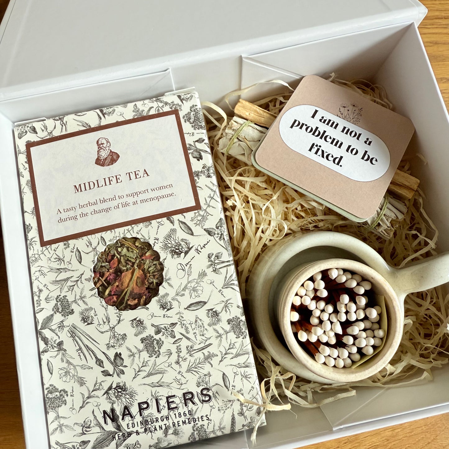 Gift set with 'Midlife Tea' package, teapot, and matches in a box.
