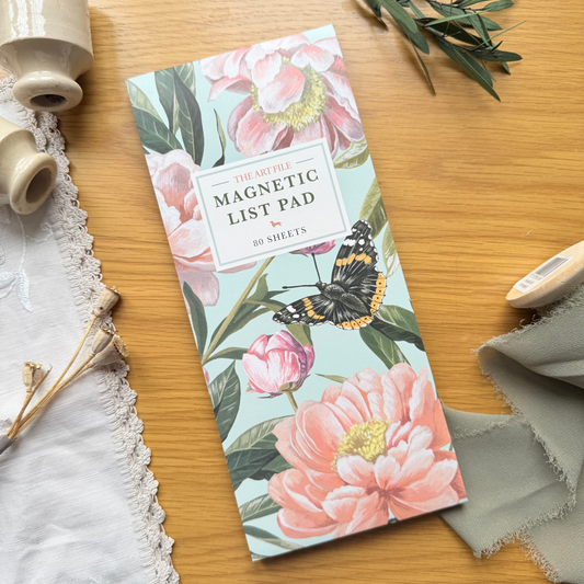 Magnetic list pad with floral design on a wooden surface