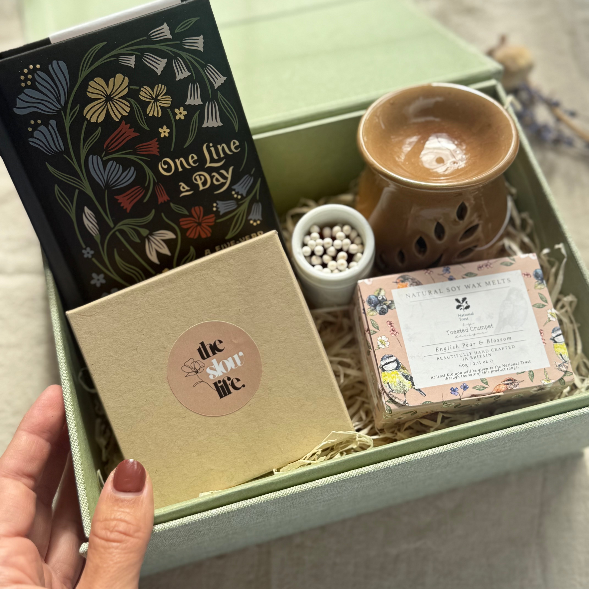 Gift box with a notebook, mug, and other items on a light surface