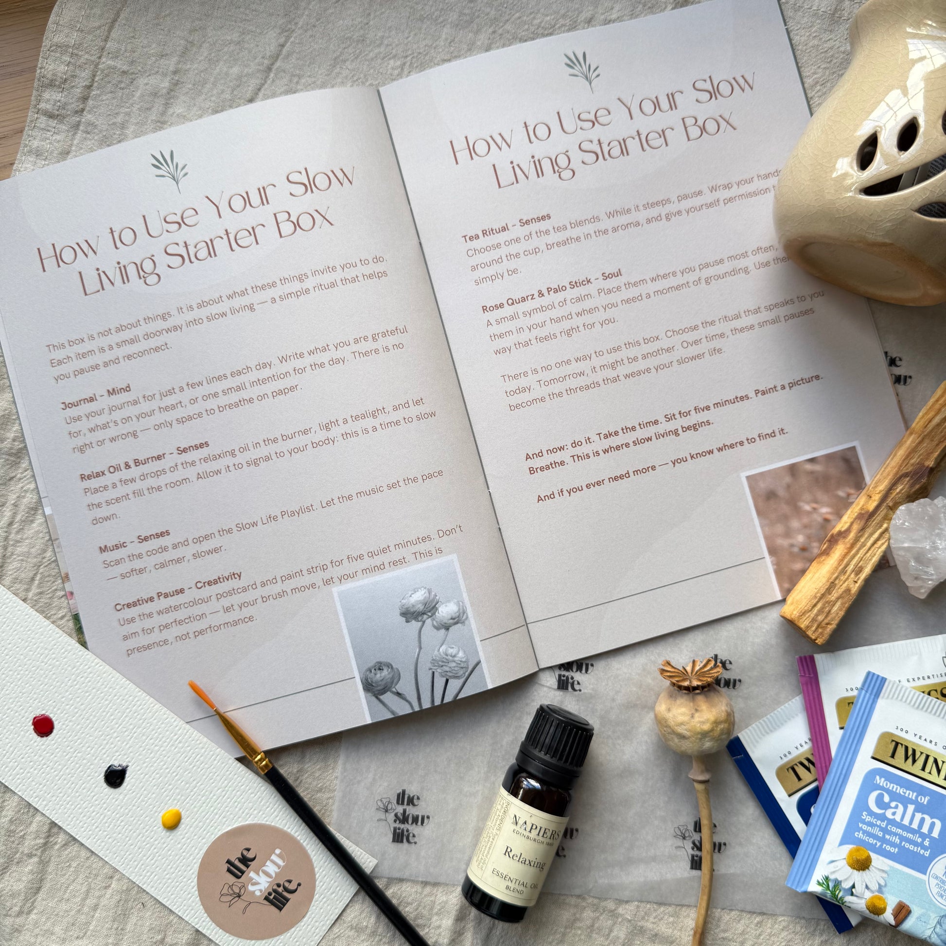 Open manual titled 'How to Use Your Slow Living Starter Box' with various items on a textured surface.
