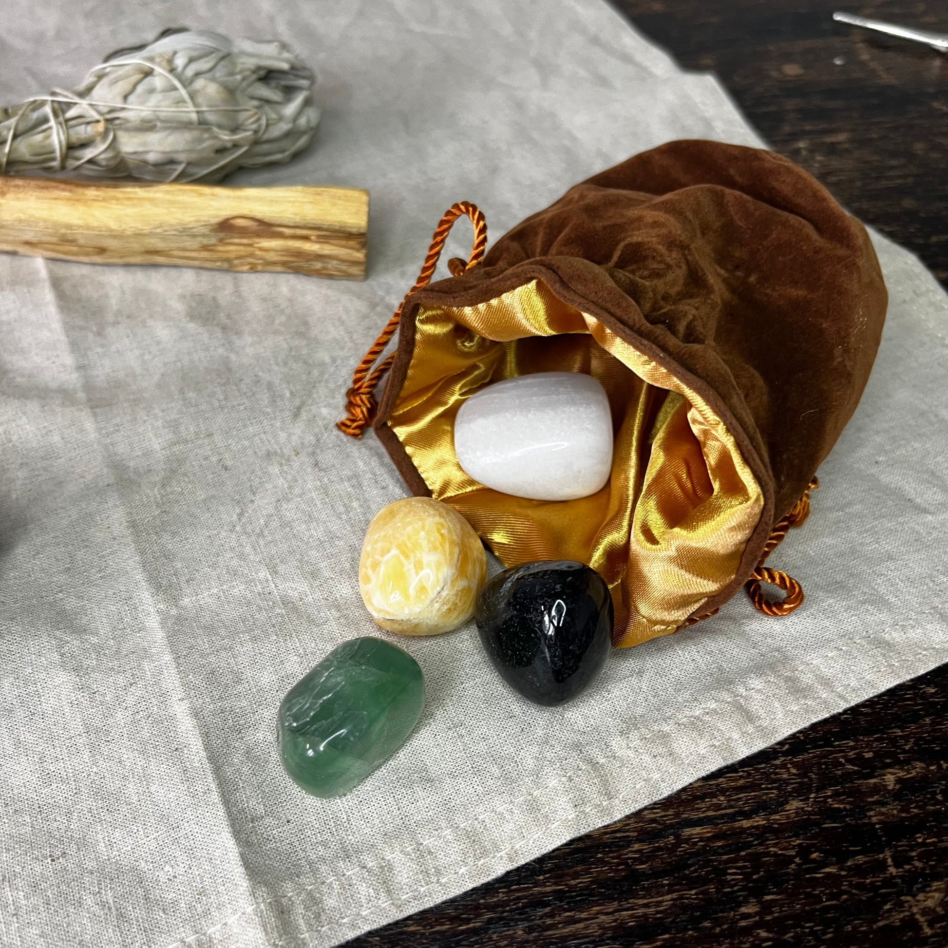 Detailed view of the Orange Calcite, Green Fluorite, White Onyx, and Black Agate crystals from the Mindfulness Crystal Set, highlighting their distinct properties and beauty.