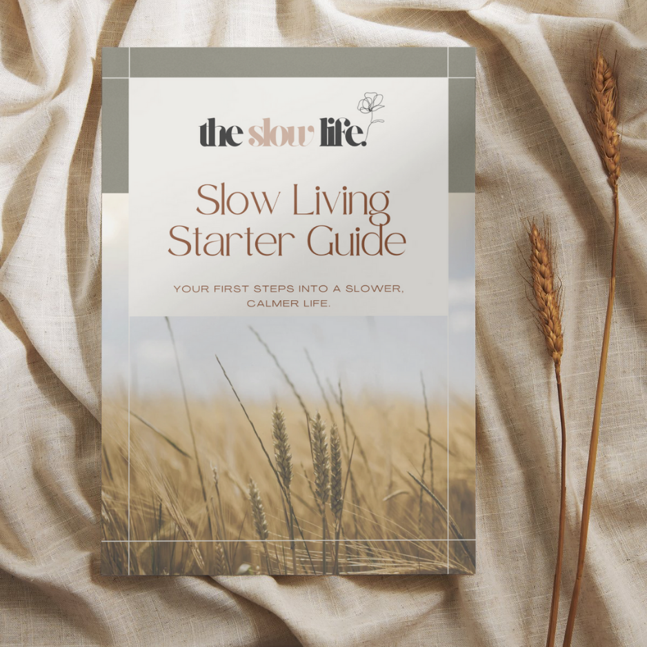Book titled 'Slow Living Starter Guide' by 'the slow life' on a fabric background with wheat stalks.